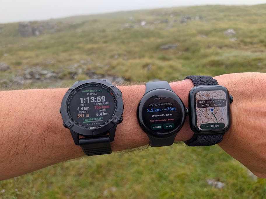 Garmin, Pixel Watch and Apple Watch being tested together on a wet Highland hill